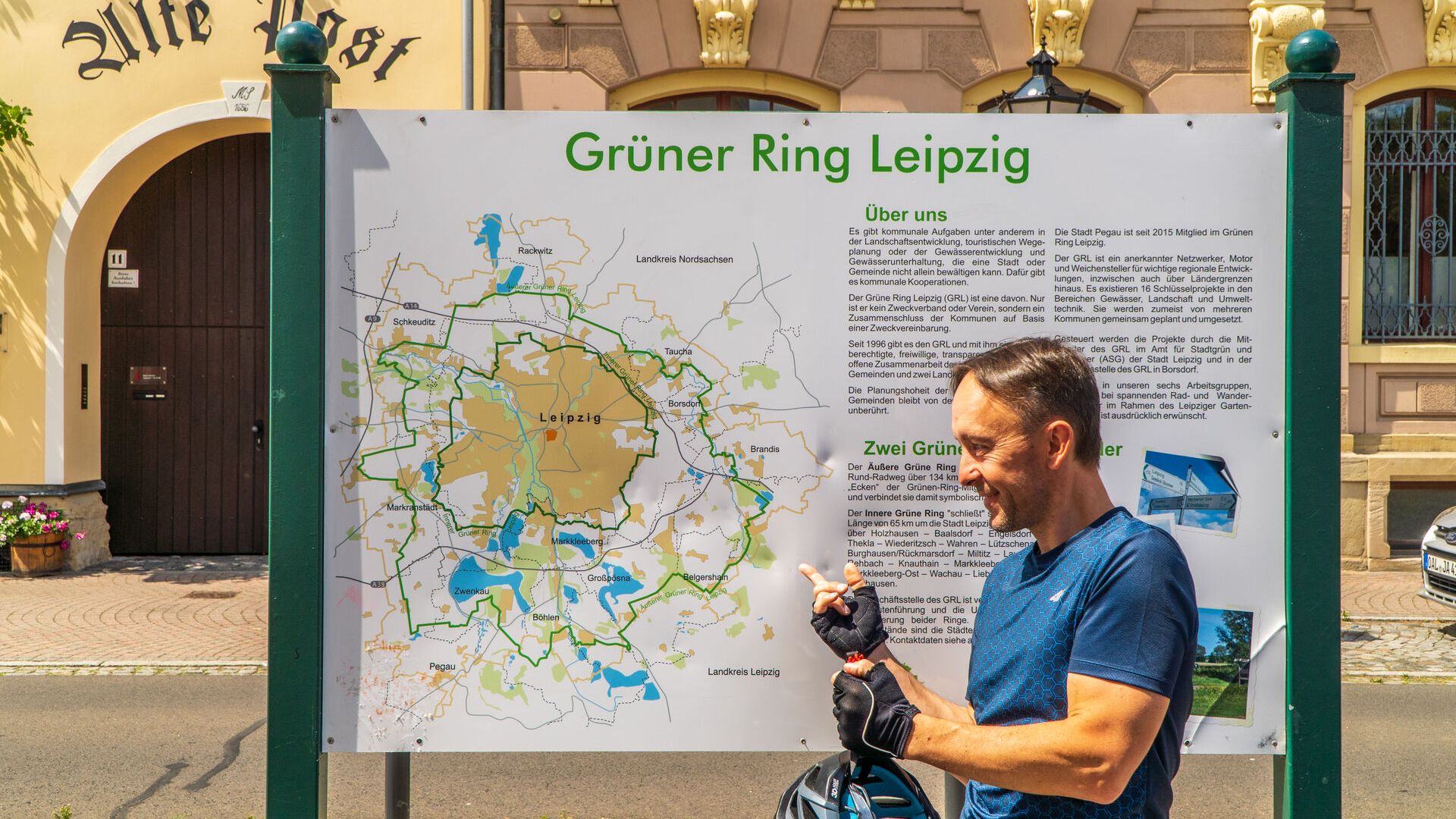 Fahrradfahrer mit der Karte vom Grünen Ring im Hintergrund, Radfahren in der Region, Freizeitaktivitäten, Aktiv, Radtouren