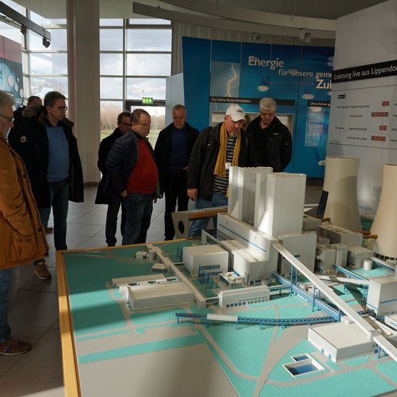 Das Bild zeigt eine Gruppe Besucher, welche sich ein Modell des Kaftwerks im Besucherzentrum anschauen.