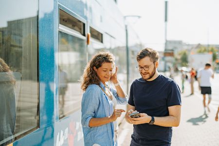 Eine Frau und ein Mann informieren sich über den ÖPNV in Leipzig.